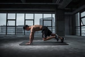 Man doing a home workout on the floor using one of the 11 best fitness apps to guide him
