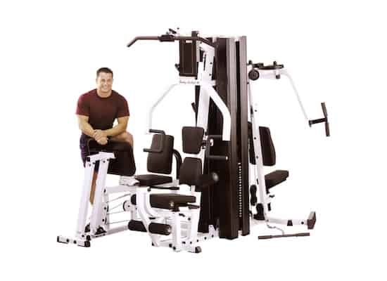 Man in red shirt standing next to EXM3000lps home gym
