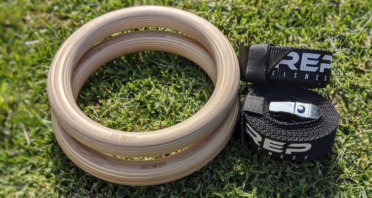 Rep Fitness wood gymnastic rings with straps lying on grass