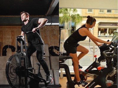 Man on an air bike next to a woman on a peloton spin bike