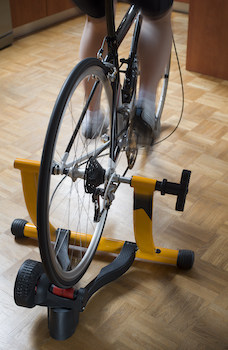 Woman using an indoor cycle trainer with a real road bike