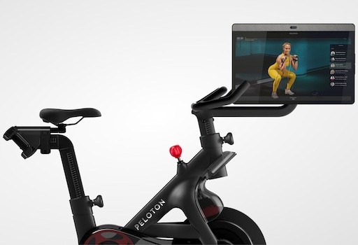 Peloton bike with touchscreen showing personal trainer 