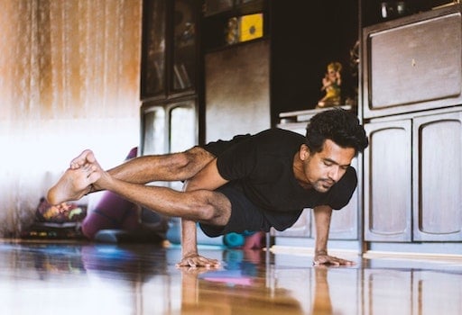 Man doing difficult yoga pose at home