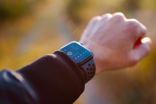 Person looking at fitness watch to get themselves motivated to workout at home