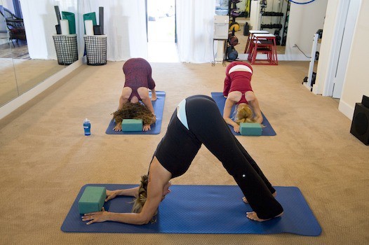 Three women doing yoga poses in a home gym