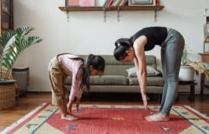 Mother and daughter showing ways to improve flexibility at home