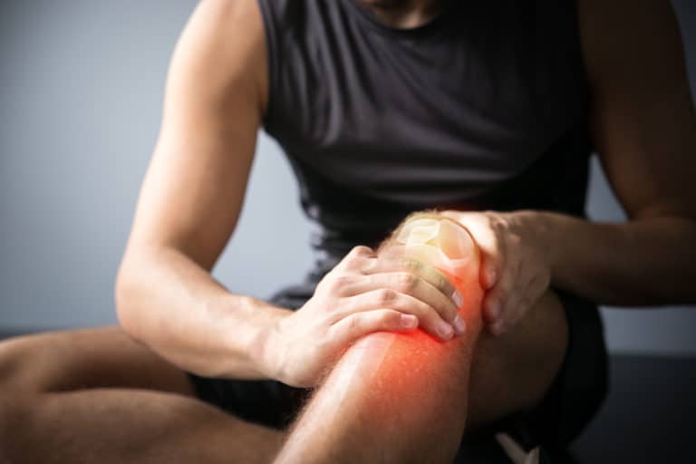 Man clutches at knee in pain