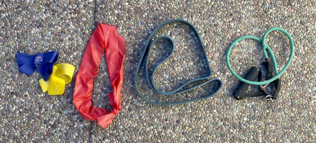 Four different types of exercise bands on the ground.