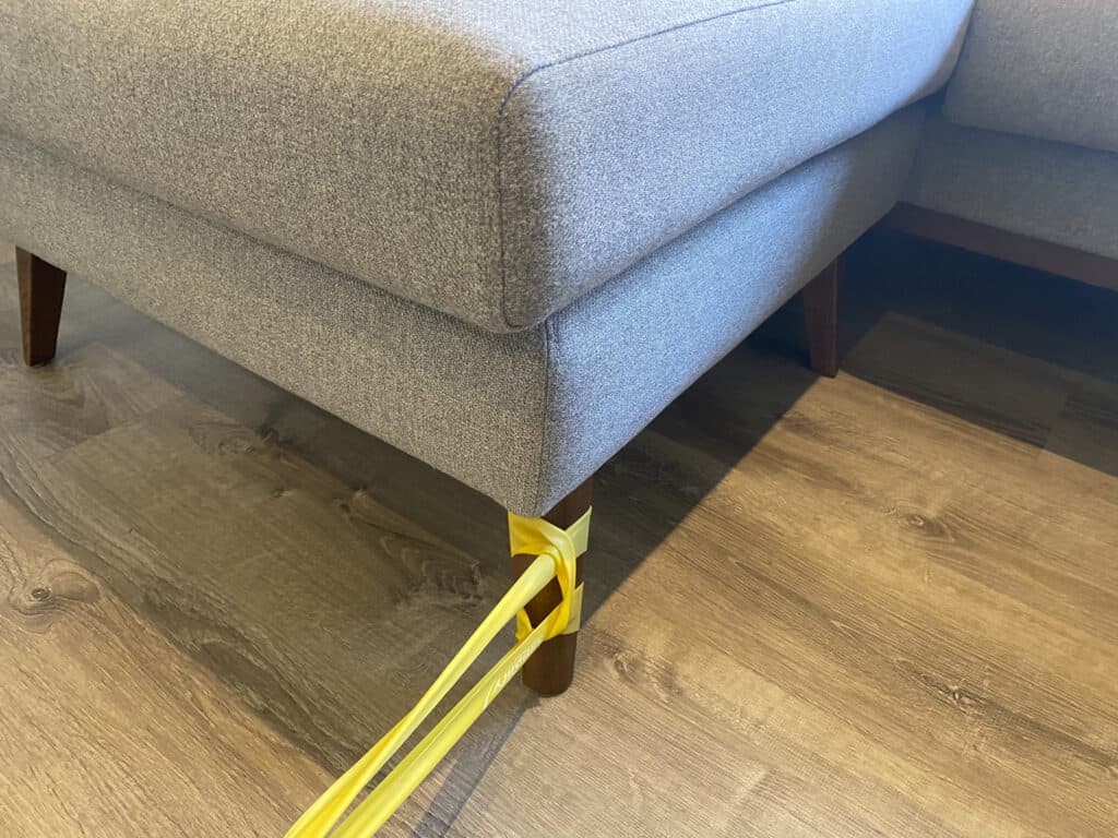 Exercise band attached to couch leg
